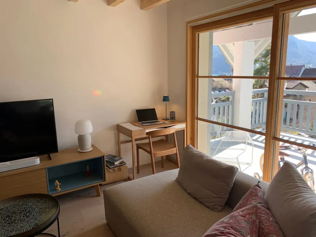 Living room and its small desk overlooking the terrace – Le Duplex de Talloires