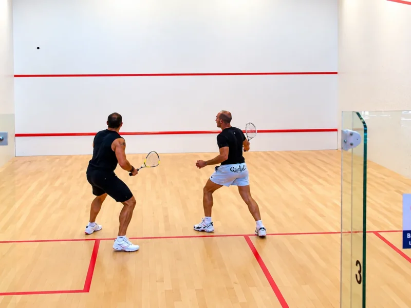 Deux joueurs en plein échange sur un court de squash