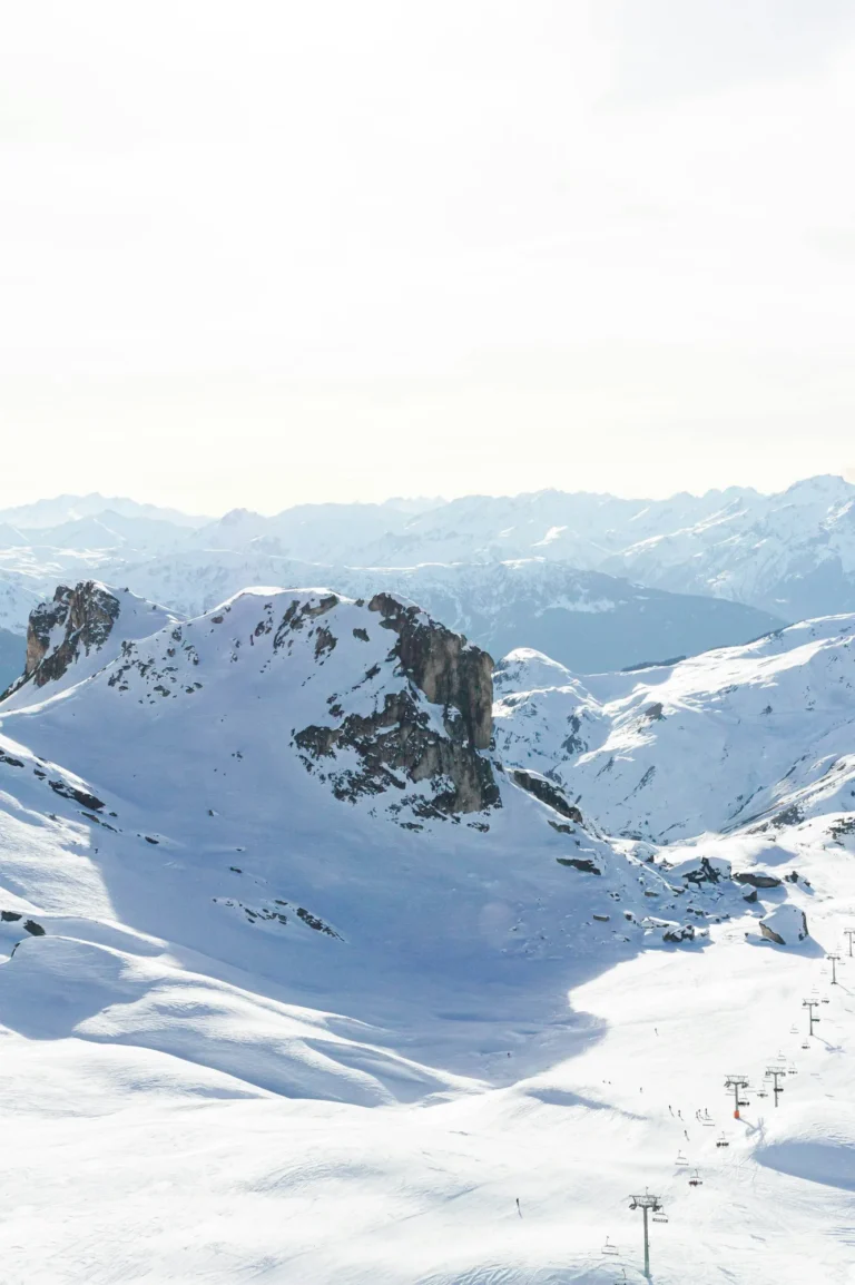 Domaine skiable enneigé et télésièges, face aux Alpes