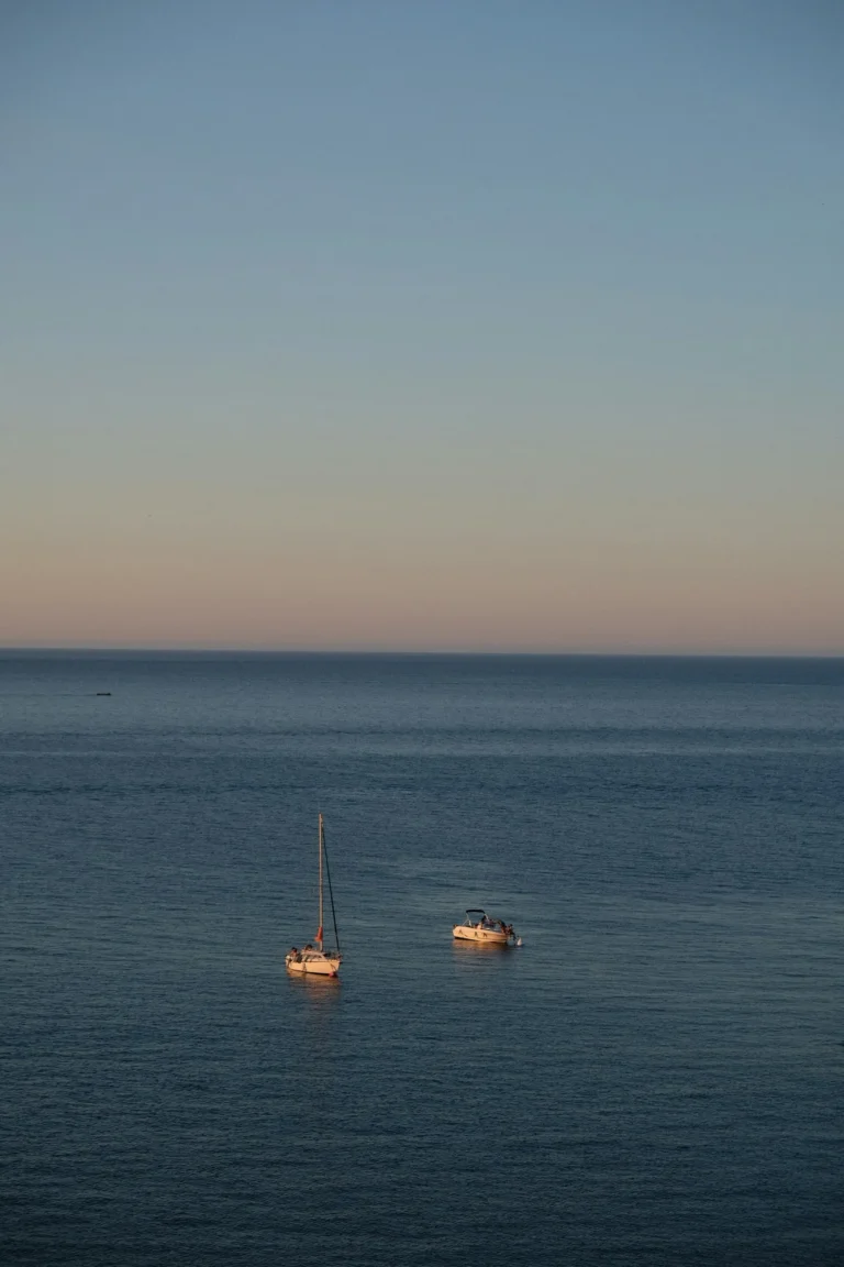 Voilier et bateau au mouillage sur la Méditerranée au coucher du soleil